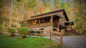 A rustic cabin with a stone foundation, wooden exterior, and a porch with a lattice railing. - 🌲Easy Paved Access🔥Fireplace❤️Great Privacy🏞️Across River🎇NearDowntown🙂 (Blue Ridge)