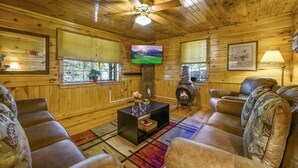 A cozy cabin interior with wooden walls, a fireplace, a television, and comfortable seating. - 🌲Easy Paved Access🔥Fireplace❤️Great Privacy🏞️Across River🎇NearDowntown🙂 (Blue Ridge)