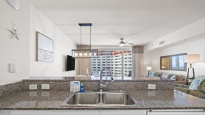 A modern kitchen with granite countertops, a double sink, and a Bosch dishwasher. - Summer Deals!! Gulf Front, Beach Access + Parking! 17th Floor! Winter $1800/mo! (Panama City Beach)