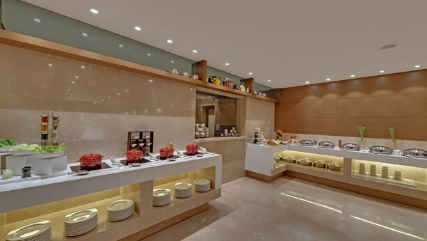 Un buffet moderne, doté de plusieurs points de service, chacun proposant une variété de plats et d’ustensiles.