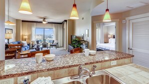 Una habitación de hotel con cocina americana, una mesa de comedor, un sofá y una cama.
