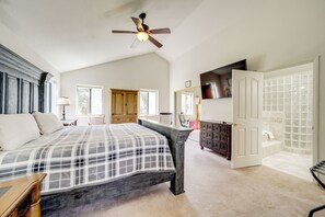 A bedroom with a bed, a ceiling fan, a dresser, a chair, and a bathroom with a shower and toilet. - 'Rocking Horse Ranch' 5BR Cabin in Payson (Payson)