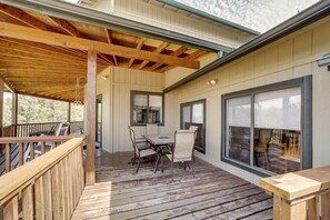 A wooden deck with a table and chairs, large windows, and a railing. - 'Rocking Horse Ranch' 5BR Cabin in Payson (Payson)