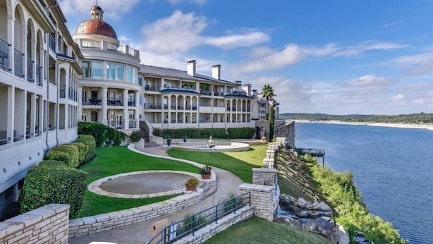 A waterfront hotel with a central courtyard, multiple balconies, and a view of the sea. - `Lakeside Haven`- Hot Tub, Pool, Lake view! (Lago Vista)