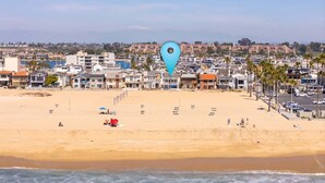 A beach with a row of houses, a lifeguard tower, and a blue location pin. - 5 Bedrooms on the Boardwalk w/4 Car Garage/Firepit (Newport Beach)