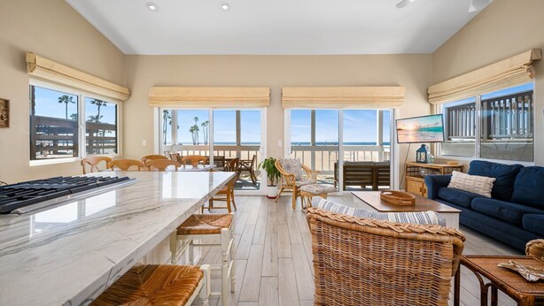 A spacious living area with a large marble island, wicker furniture, and a view of the beach. - 5 Bedrooms on the Boardwalk w/4 Car Garage/Firepit (Newport Beach)