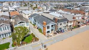 Un quartier résidentiel en bord de mer, avec des maisons dotées de balcons et une plage en premier plan.