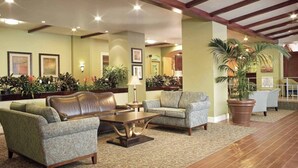 Eine großzügige Lobby mit Ledersofas, einem Couchtisch und Topfpflanzen.