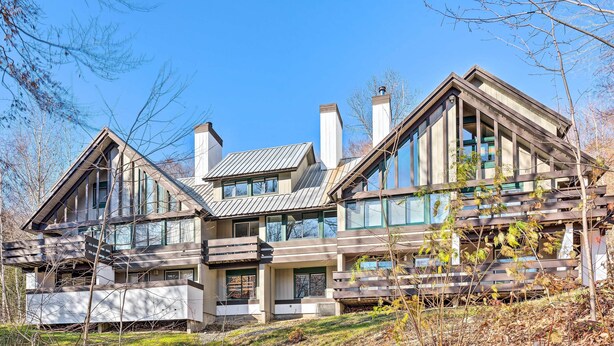 A modern multi-story house with large windows and a sloped roof. - Lincoln Retreat w/ Village of Loon Amenity Access (Lincoln)