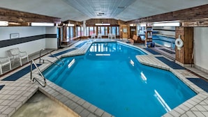 An indoor swimming pool with tiled flooring, a diving board, and lounge chairs. - Lincoln Retreat w/ Village of Loon Amenity Access (Lincoln)