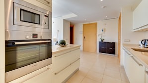 Una cucina moderna con un forno a microonde Bosch, un forno e un lavello.