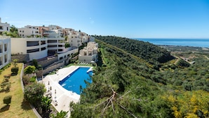 Zona residenziale con piscina, edifici moderni e vista sul mare.