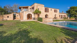 A stone building with a swimming pool, outdoor seating, and a clear blue sky. - Apartment 'Es turo de Formentera' with Pool, A/C and Wi-Fi (Ses Salines)