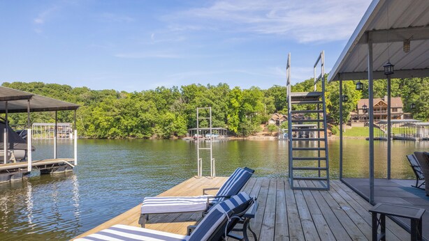 A wooden deck with lounge chairs and a covered area overlooking a lake. - Valley View 2 - Perfect for your next Lake Getaway! (Osage Beach)