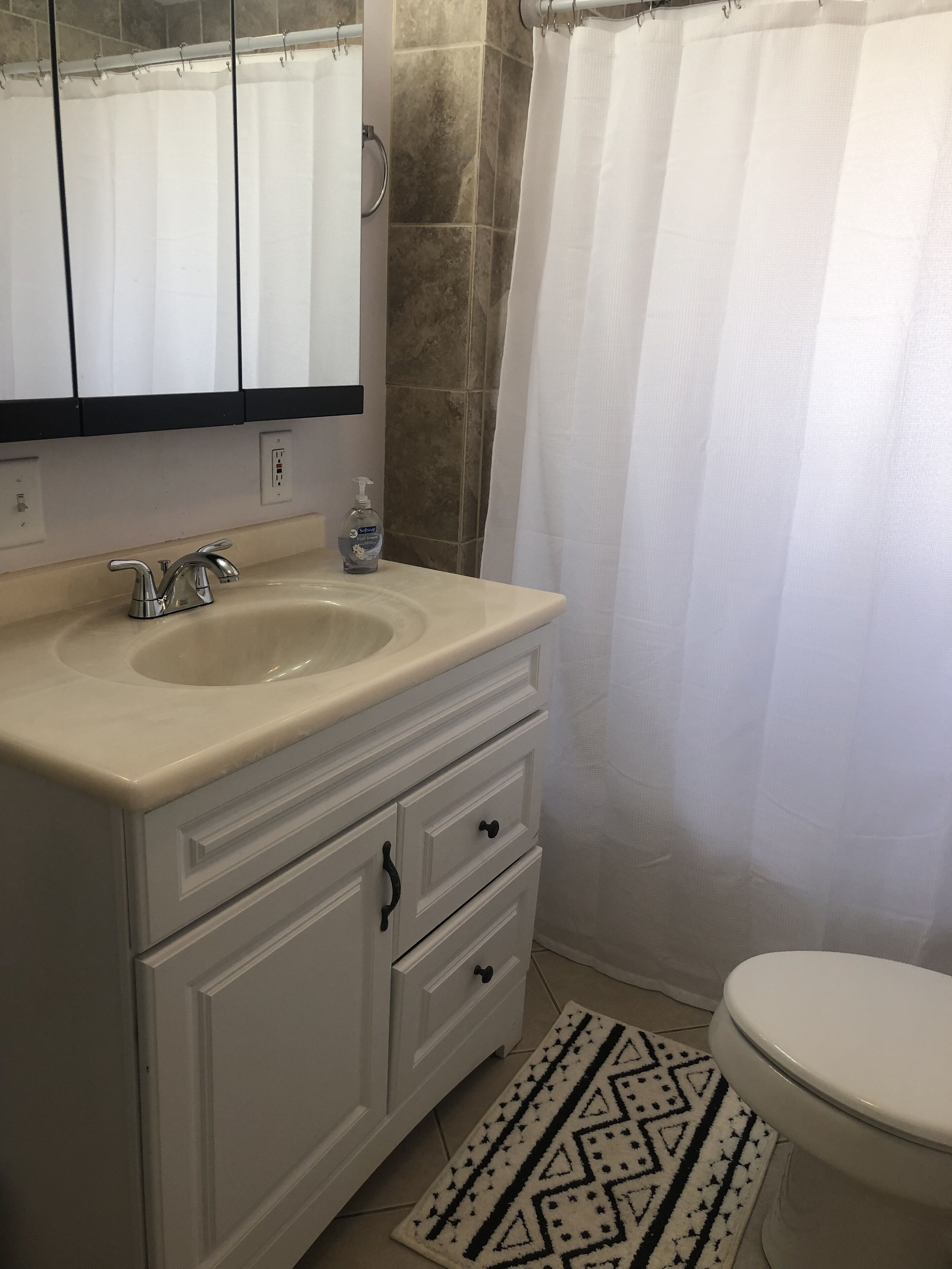 A bathroom with a sink, mirror, and toilet.