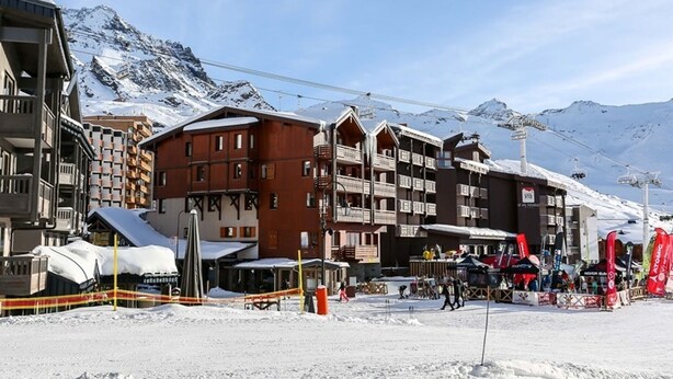 A ski resort with multi-story buildings, ski lifts, and a snowy mountain backdrop. - Ski-In/Ski-Out Apartment in Val Thorens - 6 Guests, Comfort Features, Central Location (Val Thorens)