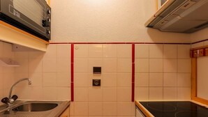 A compact kitchen with a microwave, sink, and stove. - Ski-In/Ski-Out Apartment in Val Thorens - 6 Guests, Comfort Features, Central Location (Val Thorens)