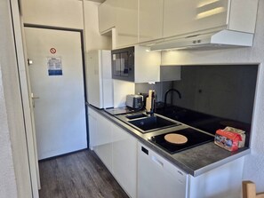 A compact kitchen with a microwave, toaster, and induction cooktop.