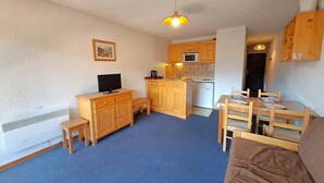 A compact living space with a kitchenette, a dining area, and a seating area. - Studio at the slopes with balcony, parking, 4 people (Les Deux Alpes)