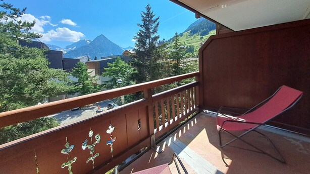 A balcony with a red chair, a view of mountains, and a clear sky. - Studio at the slopes with balcony, parking, 4 people (Les Deux Alpes)