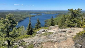 A natural landscape with a lake, trees, and rocky terrain.
