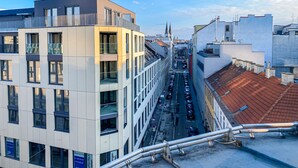 A modern building with multiple floors, large windows, and a visible street below. - Hauptbahnhof Boutique Rooms - Virtual Reception & Self-Checkin (Vienna)