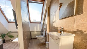 A modern bathroom with a skylight, a toilet, and a sink. - Hauptbahnhof Boutique Rooms - Virtual Reception & Self-Checkin (Vienna)