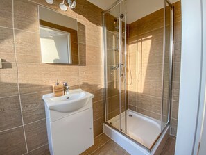 Een douche, handdoeken, zeep, shampoo