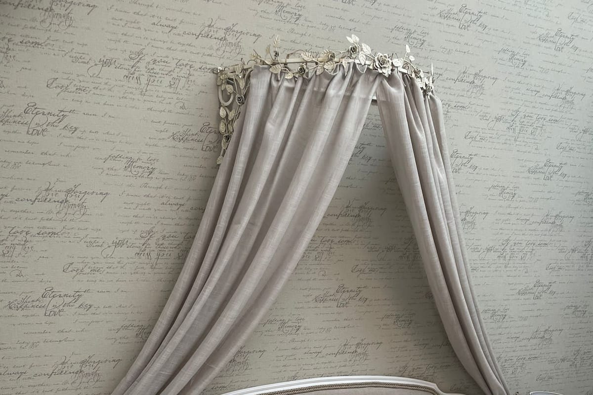Une chambre à coucher avec un lit à baldaquin, une table de chevet avec une lampe et une petite table de nuit avec une lampe.