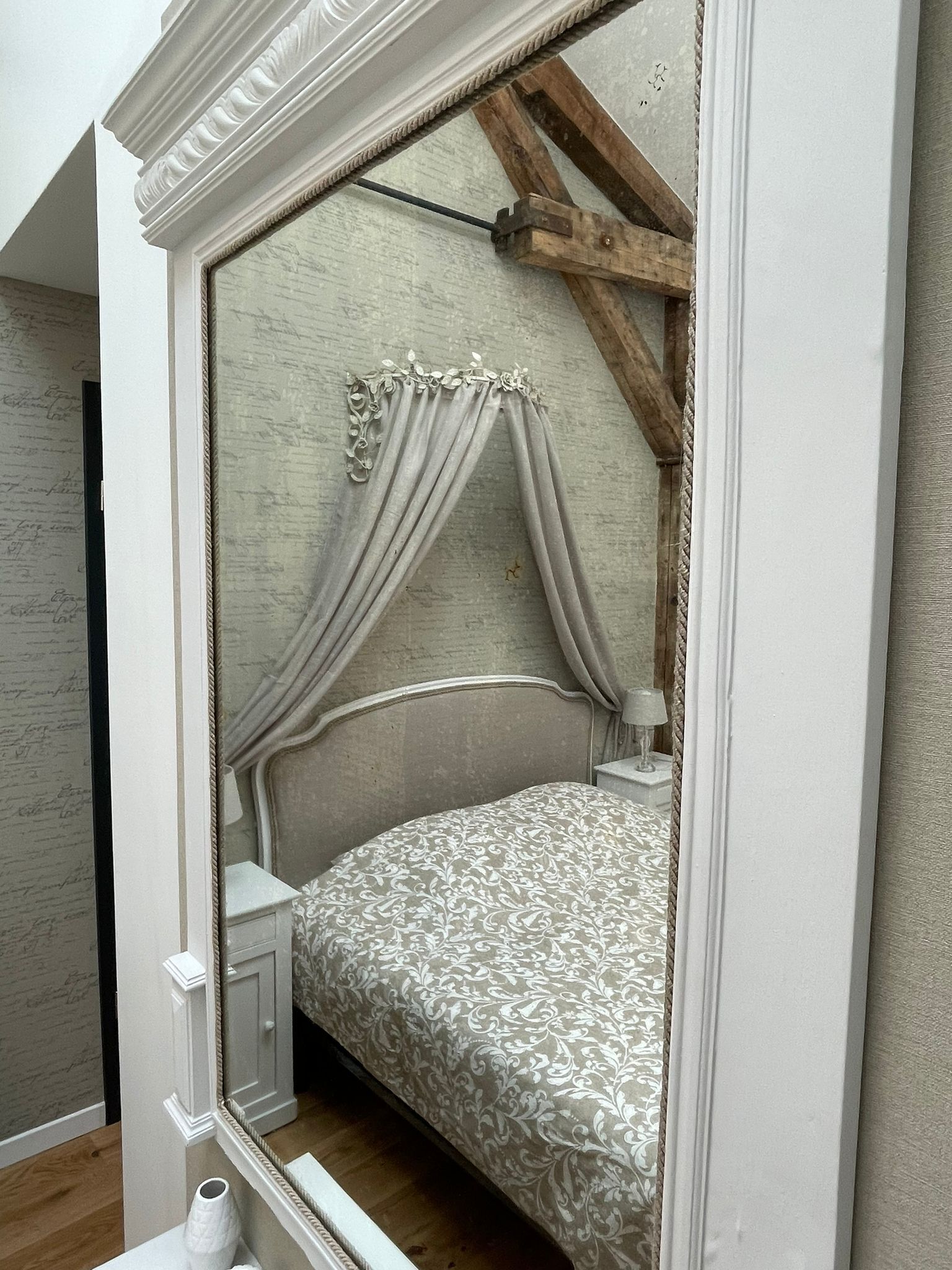 Une chambre à coucher avec un lit, une table de chevet et un miroir.