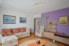 Uma sala de estar moderna com sofá, poltrona e aparador de madeira.