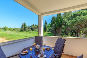 A balcony with a table set for breakfast, overlooking a green landscape. - Cuvi Beach - Park Studio (Rovinj)