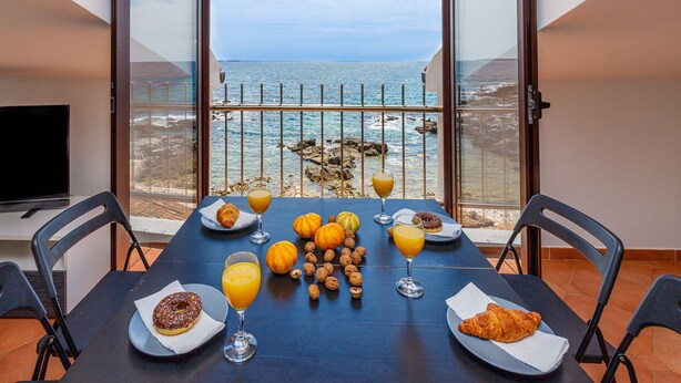 A balcony with a table set for breakfast, overlooking the sea. - Cuvi Beach - Mansarde Apartment (Rovinj)
