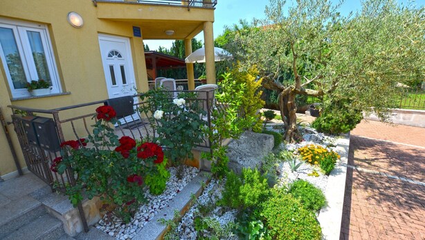 A yellow building with a balcony, white door, and outdoor seating area. - Parenzo Green Garden (Porec)