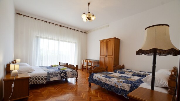 A room with two beds, a wooden wardrobe, a desk with a chair, and a lamp. - Orbanic Valalta Apartment 1 (Rovinj)