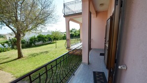 A balcony with a metal railing, a door, and a tiled floor. - Orbanic Valalta Apartment 2 (Rovinj)