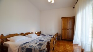 A room with a wooden bed, a wooden wardrobe, and a small table with a lamp. - Orbanic Valalta Apartment 2 (Rovinj)