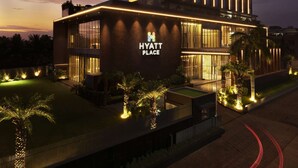 Un hotel moderno con una estructura vertical destacada y señalización iluminada.