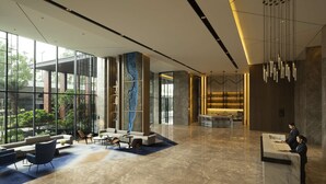 A spacious lobby with a reception desk, seating area, and large windows offering views of the outdoors. - Hyatt Place Bharuch (Bharuch)