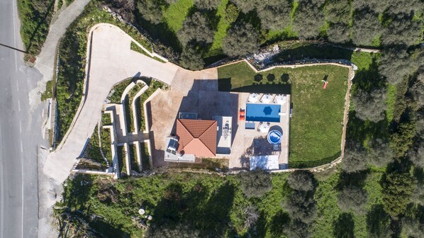 Ein Luftbild eines Anwesens mit Schwimmbad, Außenbereich zum Sitzen und einem angelegten Garten.