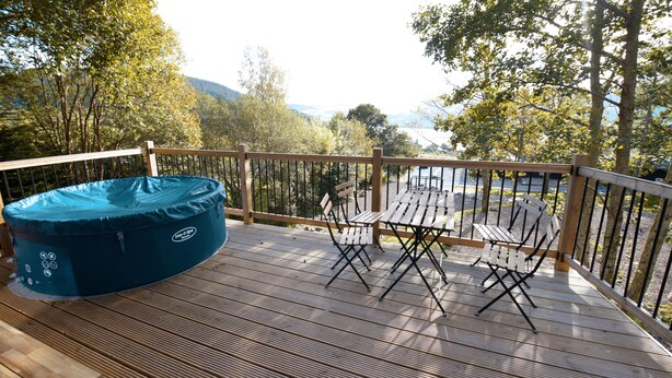 A deck with a blue inflatable pool, two wooden chairs, and a table. - Drummond (Aberfeldy)