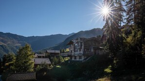 A wooden chalet with a balcony, surrounded by forest and mountains. - Chalet La Tsoum (Riddes)
