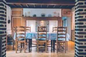 Enjoy meals in this cozy dining area with a wooden table set for four, surrounded by rustic charm.