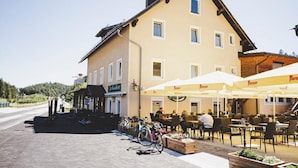A building with outdoor seating and bicycles parked in front. - Gschoadwirt (Sankt Aegyd am Neuwalde)