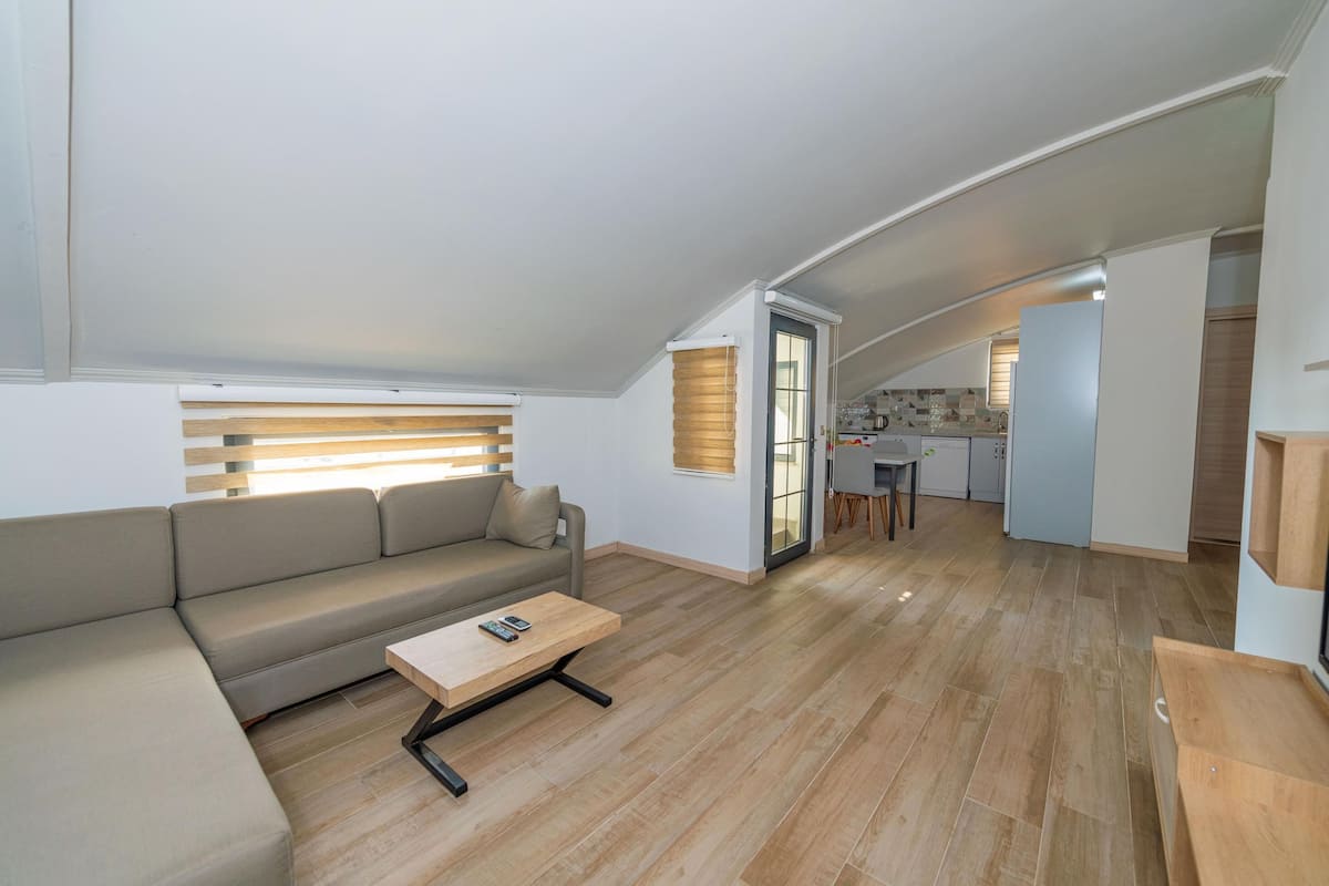Un salon moderne avec un canapé, une table basse et une cuisine en arrière-plan.