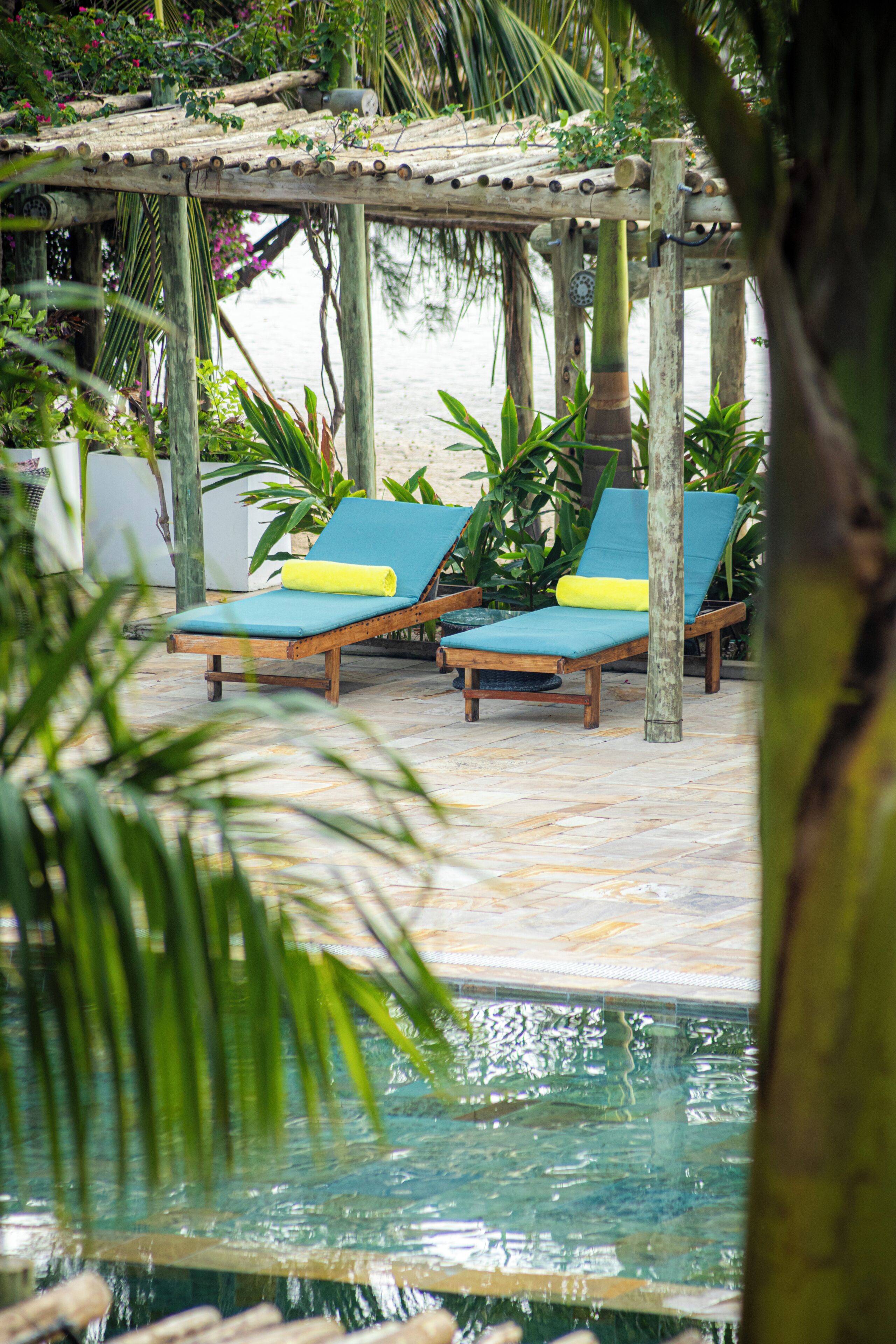 A poolside area with lounge chairs and a wooden pergola.