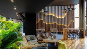 A modern interior with seating, tables, and a wooden accent wall.