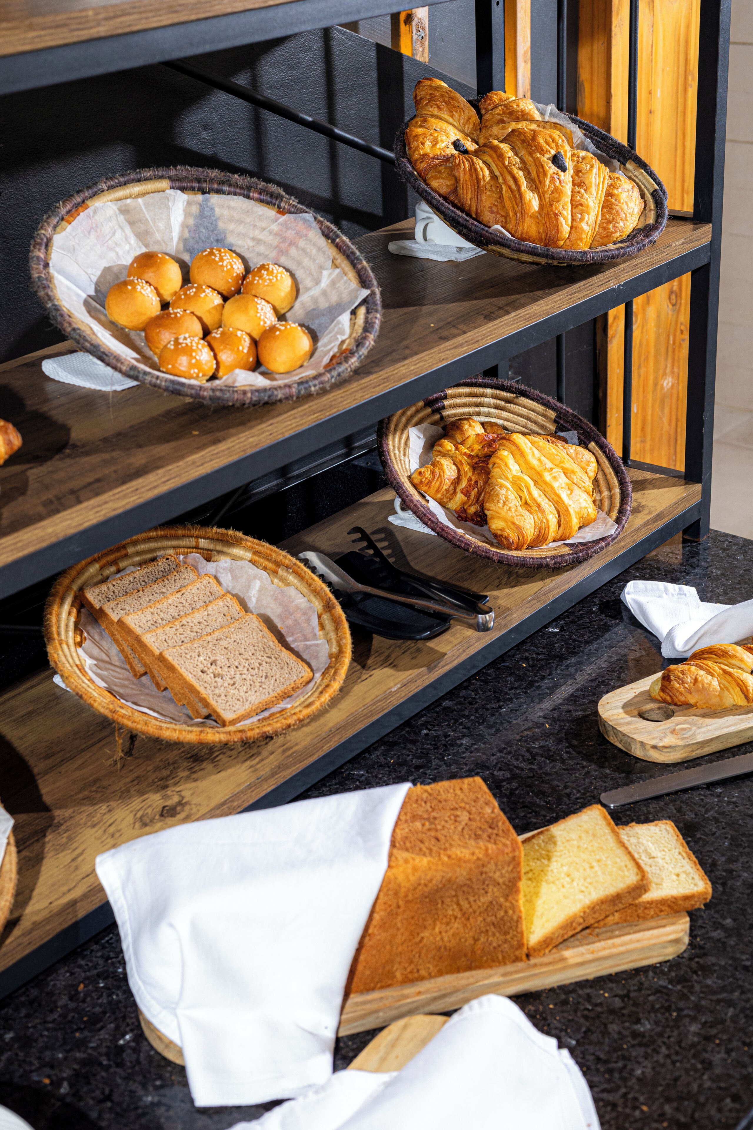 Een ontbijtbuffet met brood, croissants en broodjes.