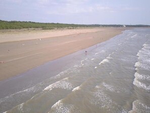 A beach with a wide sandy shore and gentle waves. - Apartment in France near the Beach (Saint Brevin L'océan)