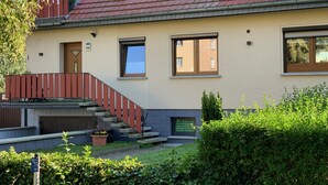 A two-story house with a red-tiled roof, a wooden staircase, and a small front garden. - Vacation apartment Bad Wilsnack (Bad Wilsnack)